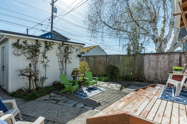 view of patio featuring fence and a deck