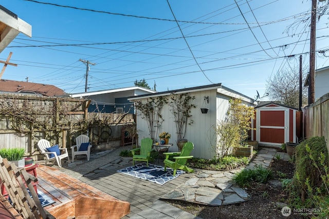 view of patio / terrace featuring a storage unit, fence, an outdoor structure, and a wooden deck