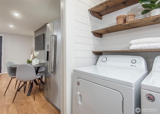 clothes washing area featuring washer and dryer, laundry area, light wood-style flooring, and recessed lighting