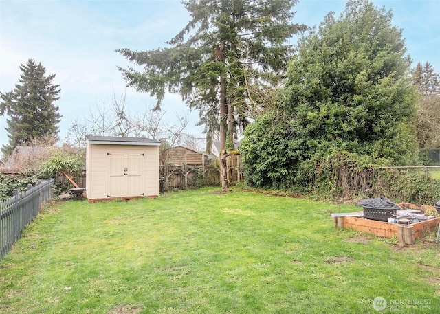 view of yard with an outbuilding, a fenced backyard, and a shed