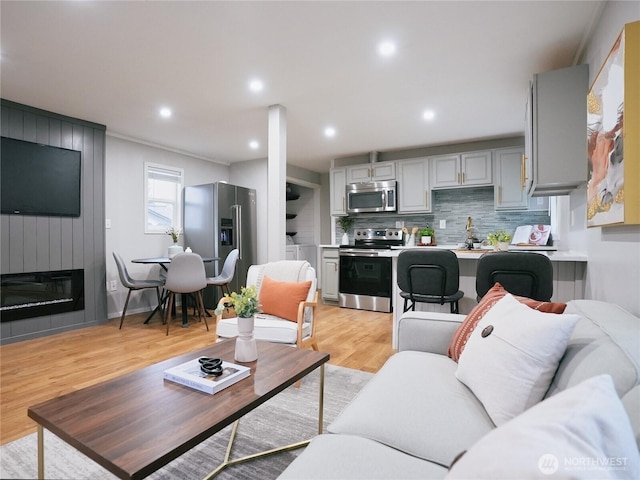 living room with recessed lighting, a fireplace, and light wood-type flooring