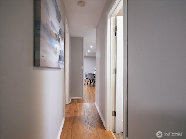 hall with recessed lighting, light wood-style flooring, and baseboards