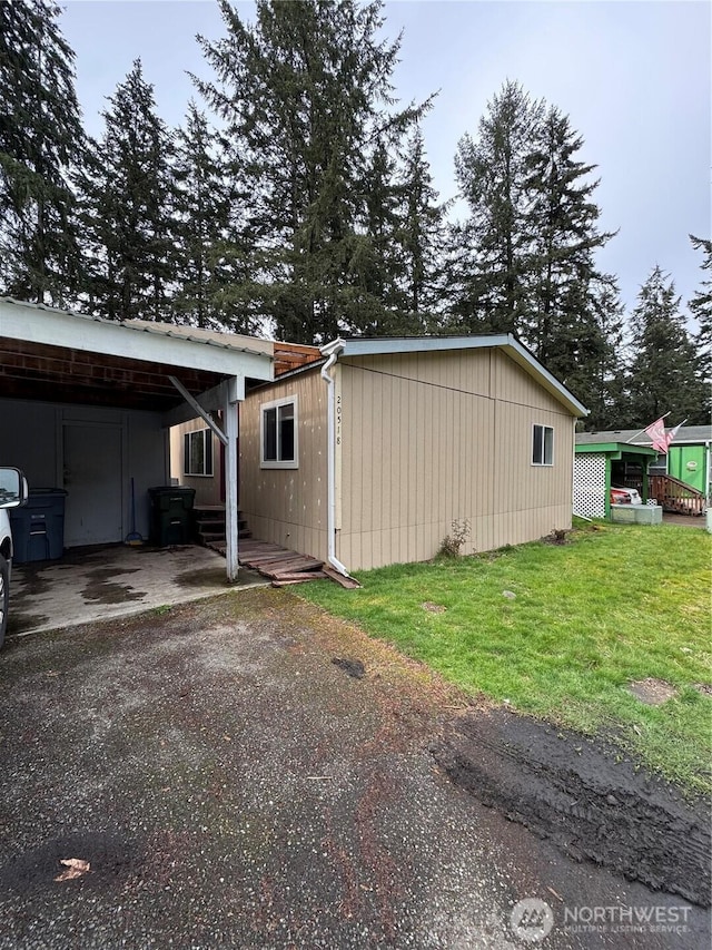 view of home's exterior featuring aphalt driveway and a yard