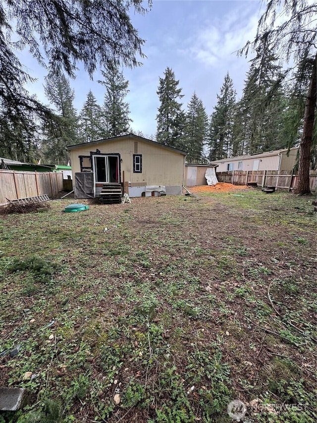 view of yard with entry steps and a fenced backyard