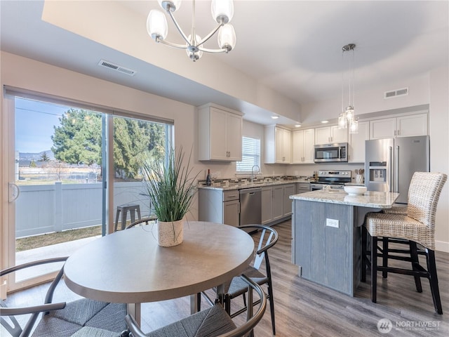 kitchen with a chandelier, visible vents, appliances with stainless steel finishes, and a sink