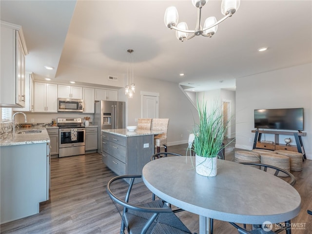 dining area with dark wood-style floors, visible vents, recessed lighting, and an inviting chandelier