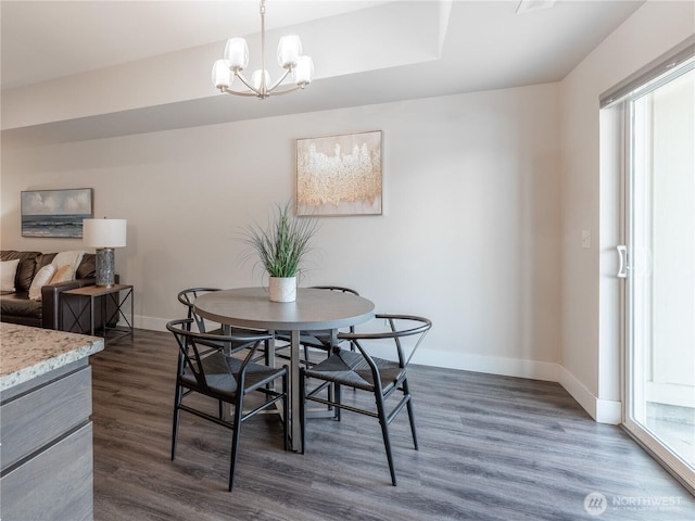 dining room featuring a notable chandelier, baseboards, and dark wood-type flooring