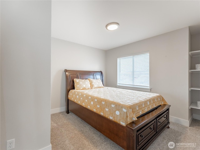 bedroom with light colored carpet and baseboards