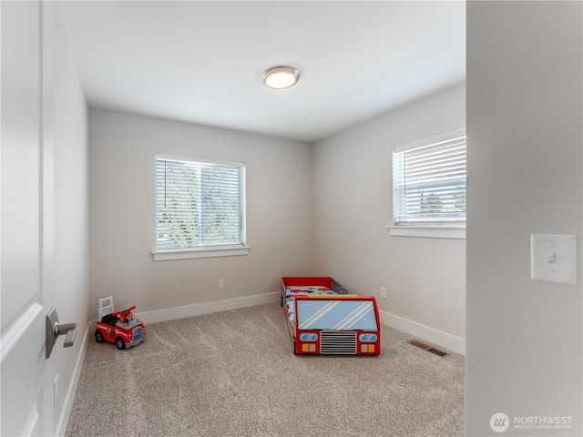 recreation room with baseboards, visible vents, a wealth of natural light, and carpet floors