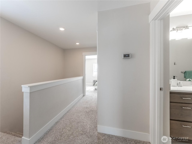 corridor with an upstairs landing, recessed lighting, baseboards, and carpet floors