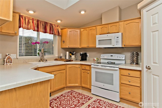 kitchen with white appliances, light tile patterned floors, lofted ceiling, light brown cabinetry, and a sink