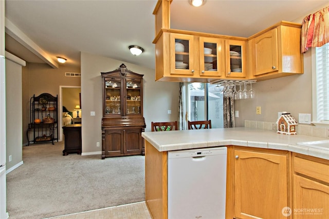 kitchen with visible vents, glass insert cabinets, light countertops, light carpet, and white dishwasher