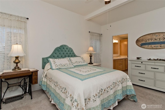 bedroom with a sink, connected bathroom, lofted ceiling with beams, and carpet floors