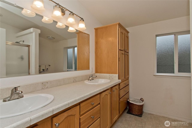 full bath featuring double vanity, a stall shower, and a sink