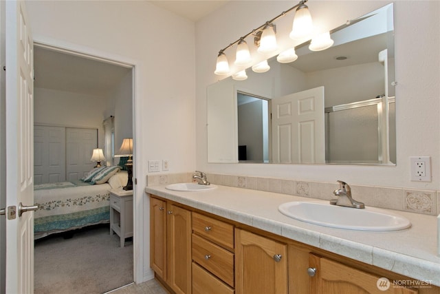 ensuite bathroom with a sink, double vanity, a stall shower, and ensuite bathroom