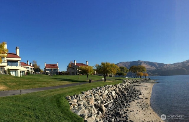 view of home's community with a yard and a water and mountain view