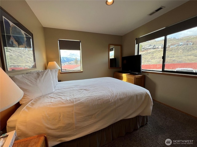 carpeted bedroom featuring visible vents