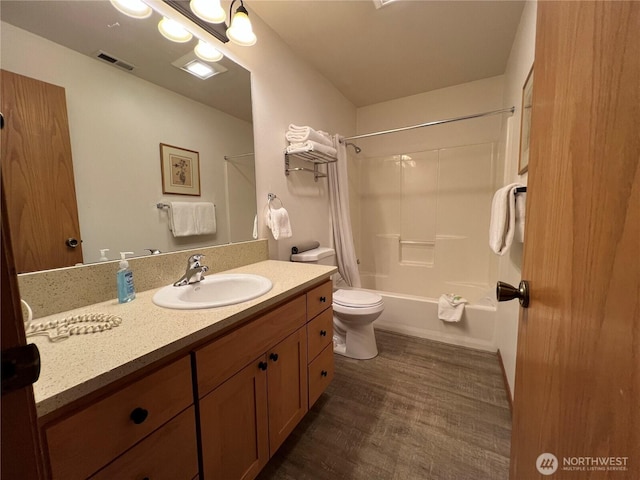 full bathroom featuring visible vents, shower / bathtub combination with curtain, toilet, wood finished floors, and vanity