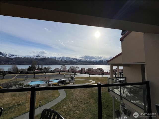 balcony featuring a water and mountain view