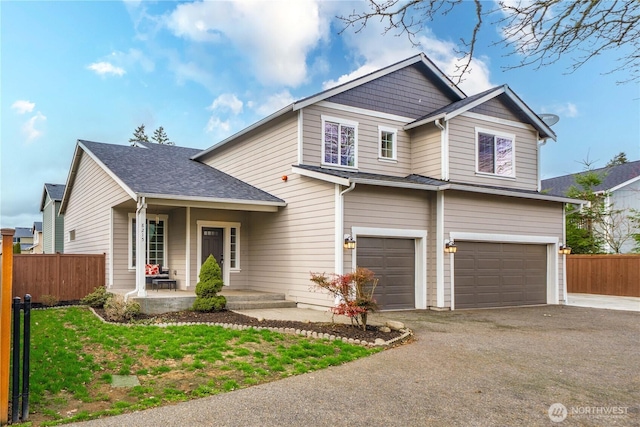 traditional home with a garage, driveway, and fence