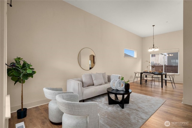 living area with an inviting chandelier, wood finished floors, and baseboards