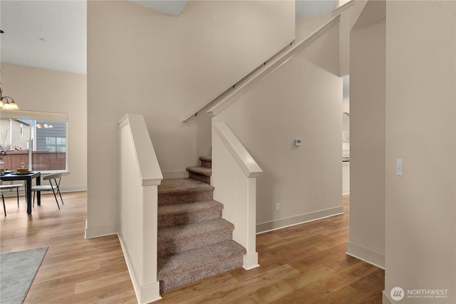 stairs featuring wood finished floors and baseboards