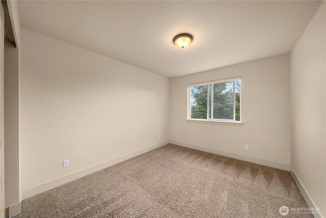 unfurnished room featuring baseboards and light colored carpet