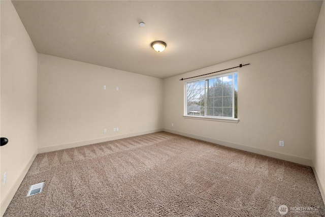 carpeted empty room with visible vents and baseboards