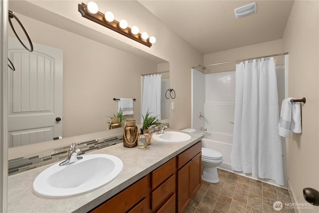 full bathroom featuring double vanity, toilet, shower / bath combo with shower curtain, and a sink