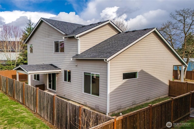 rear view of property with crawl space, a fenced backyard, and roof with shingles