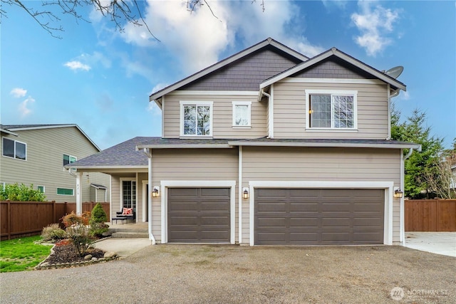 view of front facade with aphalt driveway, an attached garage, and fence