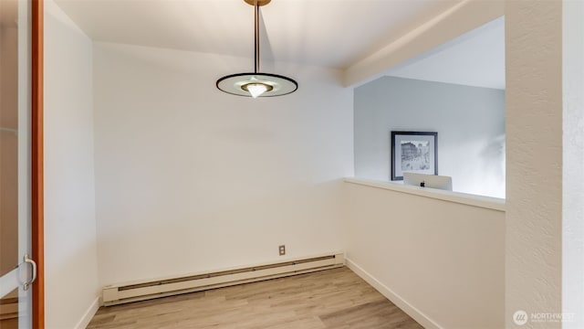 interior space featuring baseboards, baseboard heating, and wood finished floors