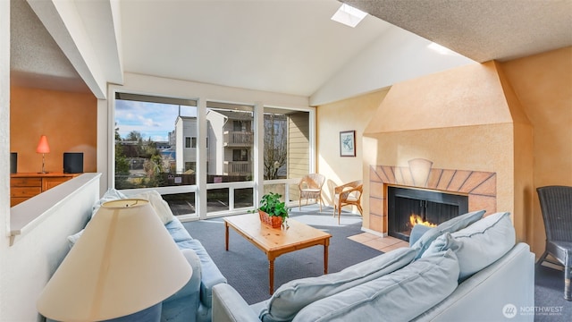 living room with vaulted ceiling with skylight and a fireplace