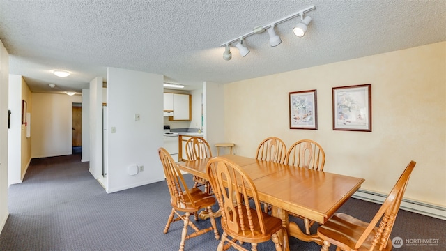 dining area featuring baseboards, carpet, rail lighting, and a textured ceiling