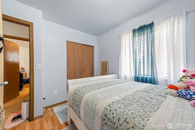 bedroom with baseboards and wood finished floors