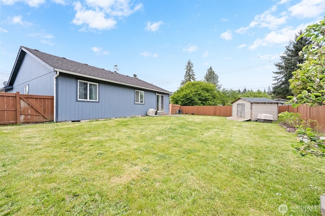 rear view of house with a storage shed, a lawn, an outbuilding, and a fenced backyard