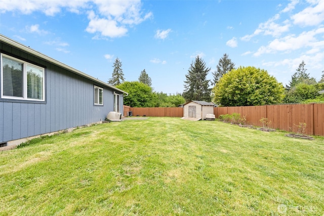 view of yard featuring a storage shed, an outdoor structure, and a fenced backyard