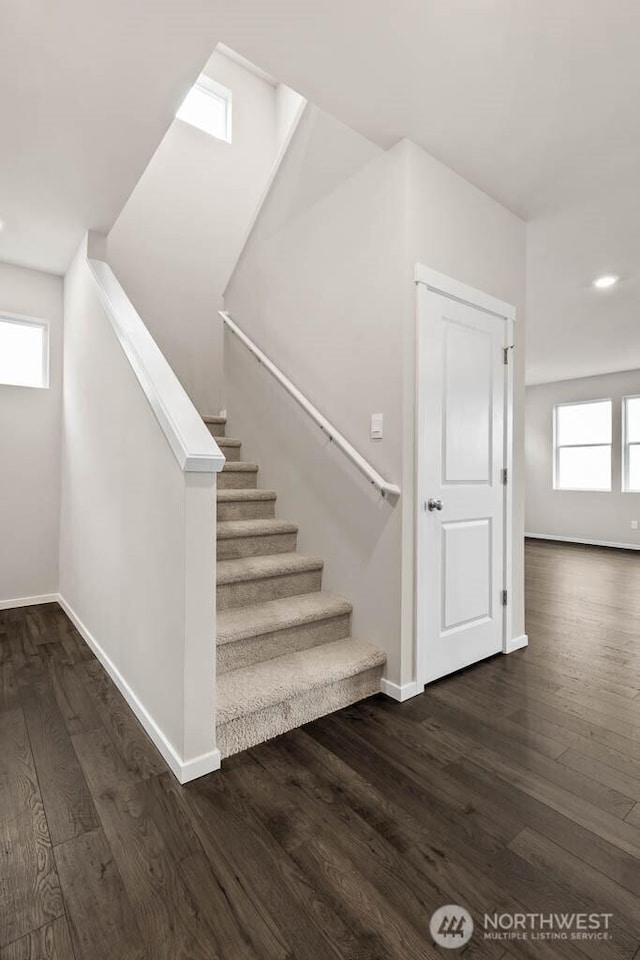 staircase with baseboards and wood finished floors