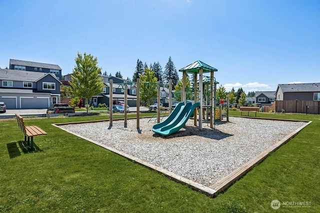 community play area featuring a yard, fence, and a residential view