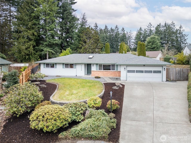 ranch-style house featuring a front yard, concrete driveway, a garage, and fence