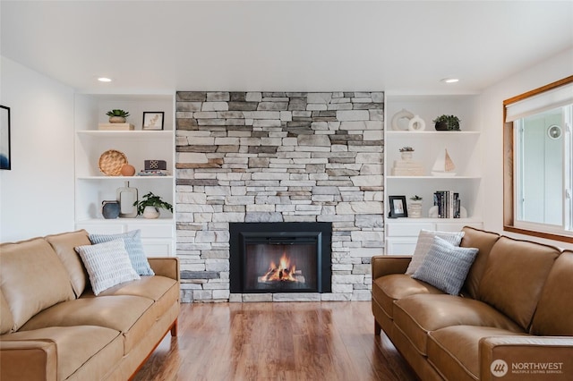 living room featuring a fireplace, built in shelves, wood finished floors, and recessed lighting