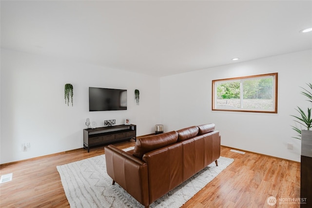 living area featuring recessed lighting, light wood-style flooring, and visible vents