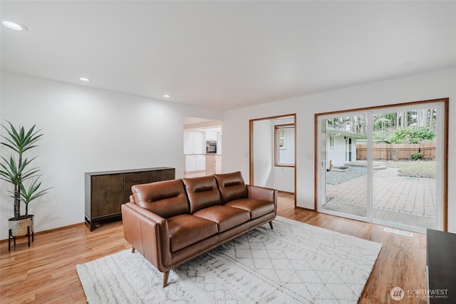 living area with recessed lighting, baseboards, and light wood finished floors