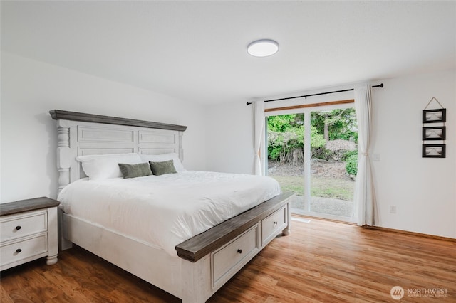 bedroom featuring access to exterior and wood finished floors