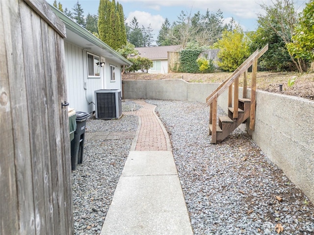 view of yard with central AC unit and fence