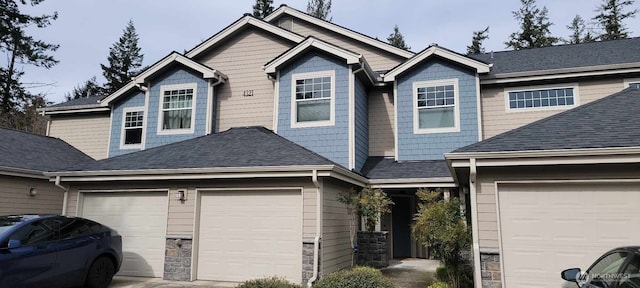 view of front of home with stone siding, an attached garage, concrete driveway, and a shingled roof