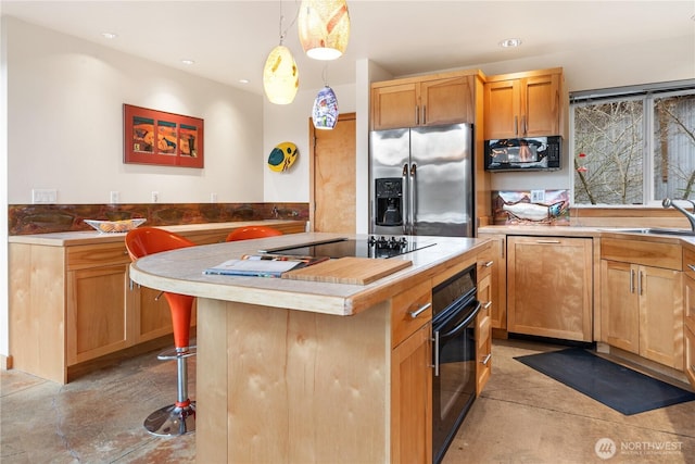 kitchen with black appliances, a sink, a kitchen island, recessed lighting, and a breakfast bar area