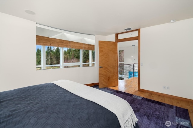 unfurnished bedroom featuring visible vents, baseboards, and hardwood / wood-style flooring