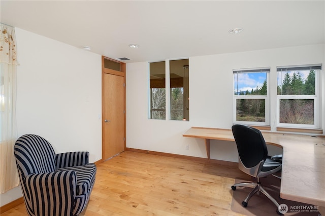 office space featuring baseboards, visible vents, and light wood finished floors