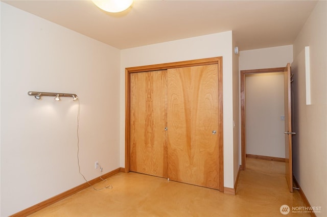 unfurnished bedroom with baseboards and a closet